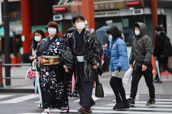 ▲3月8日，在日本东京，戴着口罩的行人过马路。新华社/路透